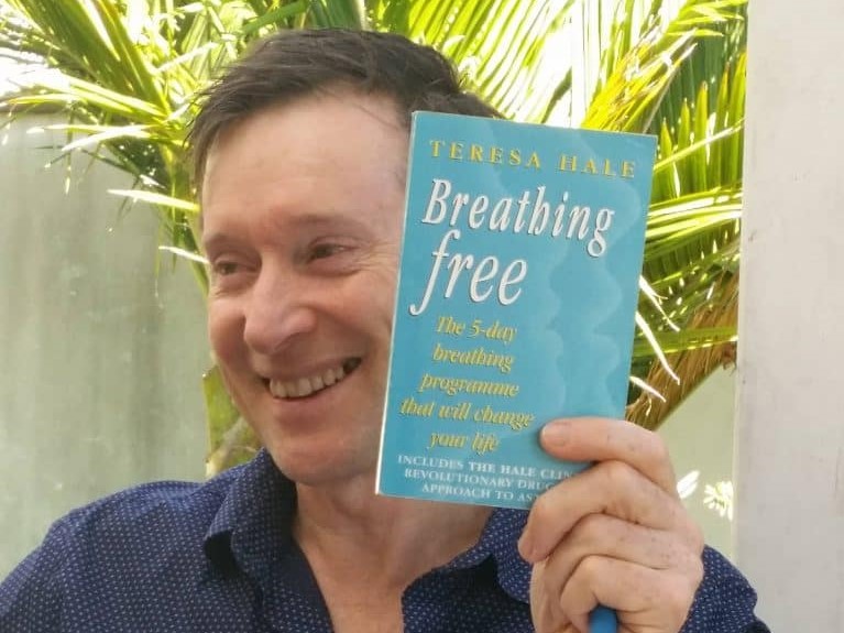 Glenn White holding the book Breathing Free by Teresa Hale